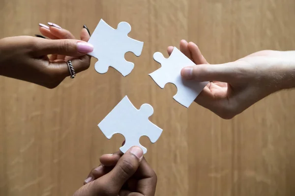 Close up of diverse people assemble jigsaw finding best solution — Stock Photo, Image