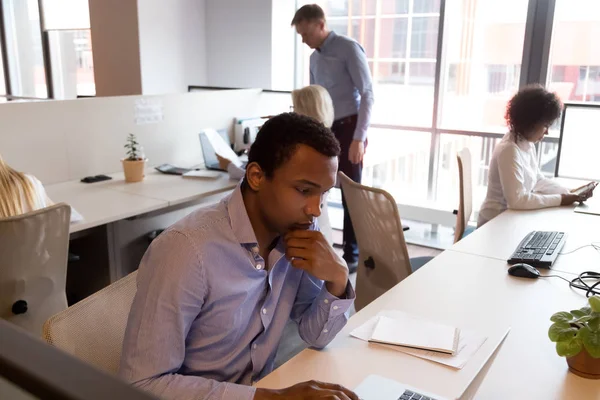 Gerichte zwarte mannelijke medewerker werken aan laptop in gedeeld kantoor — Stockfoto