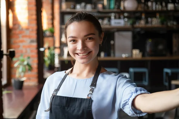 Testa ritratto di attraente cameriera sorridente in accogliente caffetteria — Foto Stock