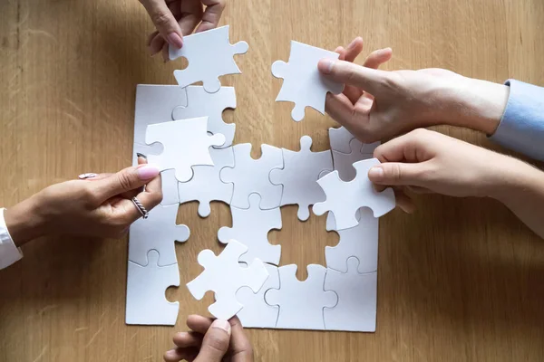 Top view of diverse people assemble jigsaw looking for solution — Stock Photo, Image