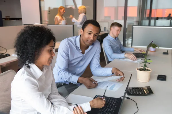 Supervisor negro masculino analiza el trabajo femenino en el lugar de trabajo — Foto de Stock