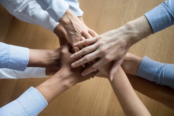 Vista superior de los colegas se unen las manos motivadas por el éxito compartido — Foto de Stock