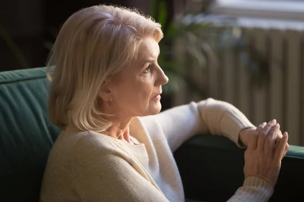 Pensive Starsza kobieta spojrzeć na odległość myślenia lub żałoba — Zdjęcie stockowe