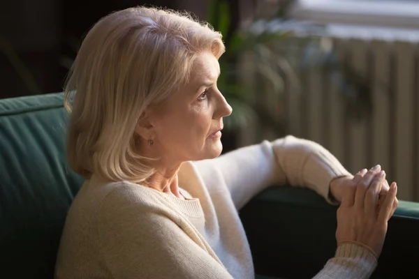 Pensive elderly woman look in distance thinking or mourning — Stock Photo, Image