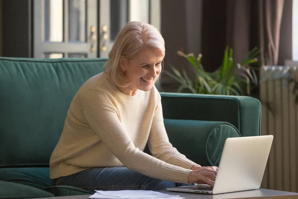 Smiling senior woman feel free using laptop at home — Stock Photo, Image