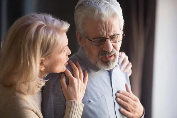 Senior vrouw helpen echtgenoot aanraken borst met hartaanval — Stockfoto