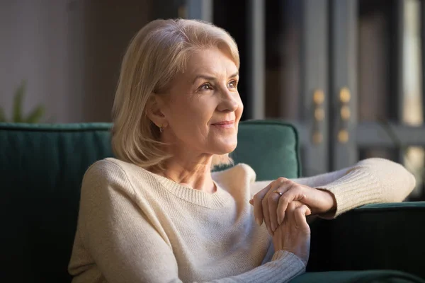 Sonriente anciana mirada en la distancia disfrutando de agradables recuerdos — Foto de Stock