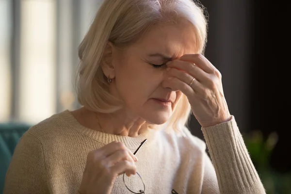 Close up of elderly woman massage eyes suffering from migraine — Stock Photo, Image