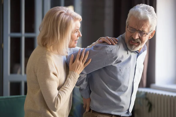 Senior vrouw zorgen voor man met rugpijn — Stockfoto