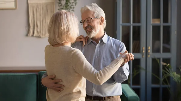 Пожилая пара наслаждается временем вместе, танцуя дома — стоковое фото