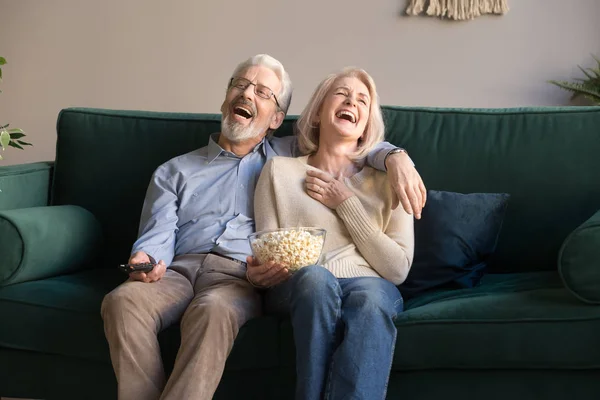 Excited mature couple laughing while watching comedy movie. — Stock Photo, Image