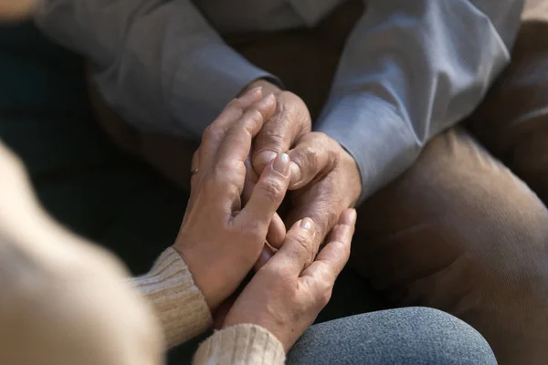 Крупный план пожилой пары держатся за руки показывая любовь — стоковое фото
