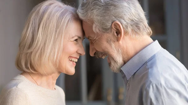Gelukkige volwassen paar aanraking voor hoofden genieten romantisch moment — Stockfoto