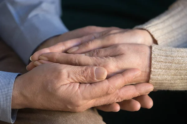 Cerca de hombre de mediana edad sosteniendo las manos arrugadas esposa . — Foto de Stock