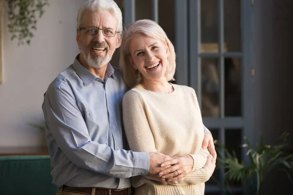 Портрет счастливых пожилых супругов, позирующих для фото дома — стоковое фото
