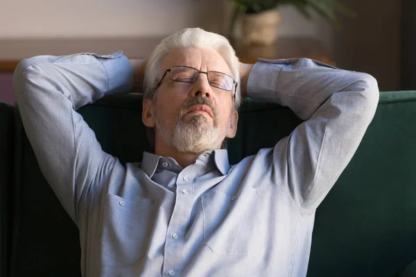 Stanco anziano uomo addormentarsi su accogliente divano a casa — Foto Stock