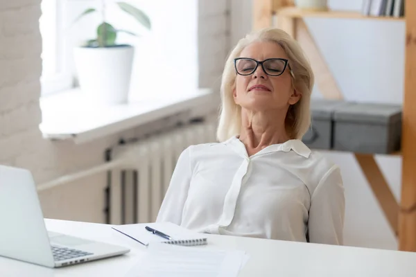Calm aged woman relax in chair with eyes closed — Stock Photo, Image