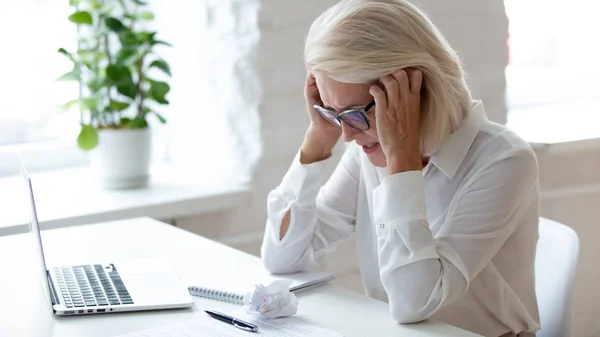 Müde gealterte Geschäftsfrau verspürt Müdigkeit, die unter Kopfschmerzen leidet — Stockfoto