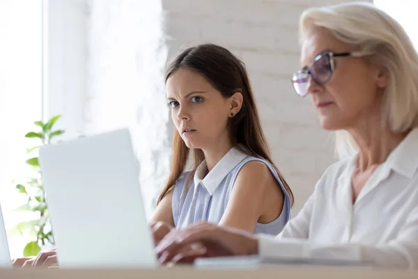 Scioccato dipendente femminile sguardo stupito sbirciando computer portatile collega — Foto Stock