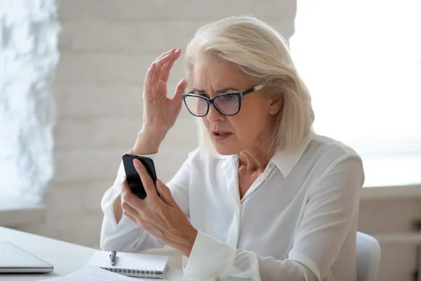 Mujer frustrada mantener el teléfono celular que tiene problemas con el dispositivo —  Fotos de Stock