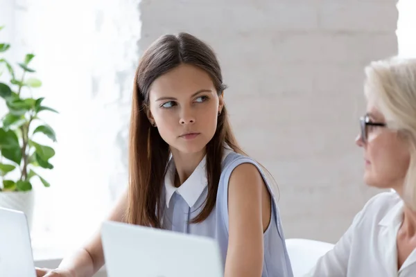 Serious female employee look angry at woman colleague in office — Stock Photo, Image