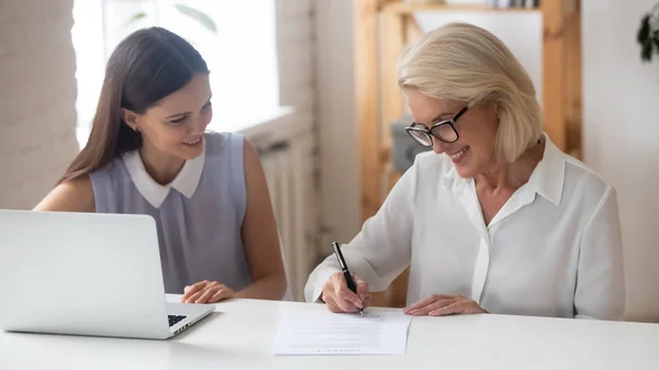 Smiling senior woman sign business contract in office — Stock Photo, Image