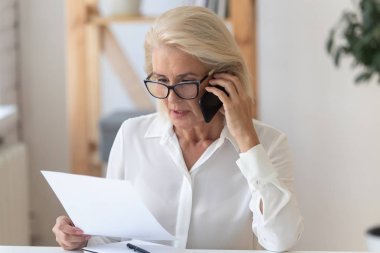 Ciddi üst düzey kadın cep telefonu evrak tartışıyor konuşmak