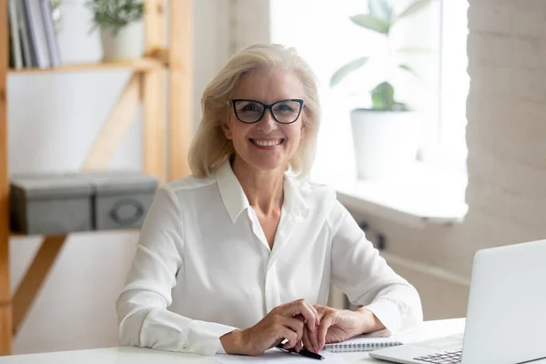 Retrato de una mujer de negocios sonriente posando en el lugar de trabajo — Foto de Stock