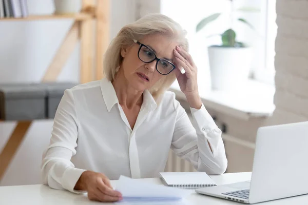 Nachdenkliche Seniorin denkt an Problemlösung im Amt — Stockfoto