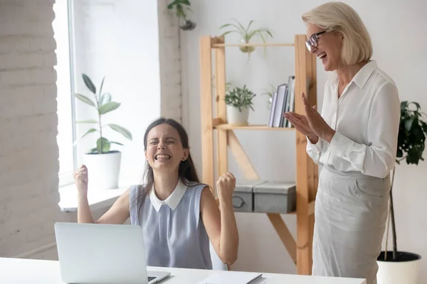 Щаслива тисячолітня жінка святкує просування роботи в офісі — стокове фото