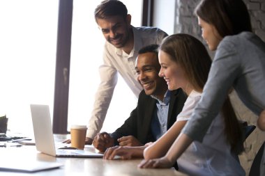 Farklı iş arkadaşları birlikte dizüstü bilgisayar kullanarak, mola sırasında eğlenmek