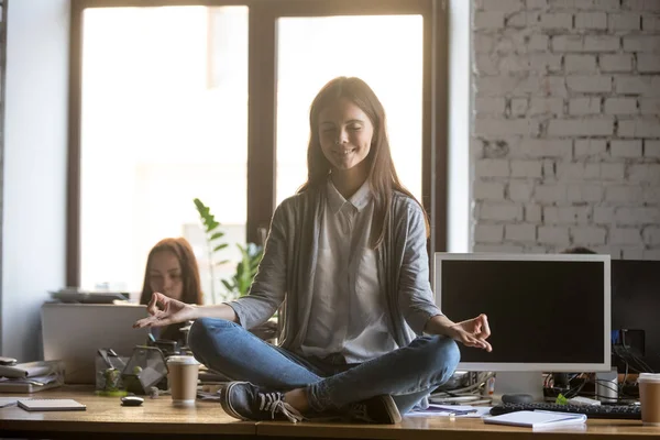 Mosolygó fiatal üzletasszony meditál, gyakorló jóga irodai íróasztal — Stock Fotó