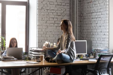 Ofis masasında meditasyon huzurlu iş kadını, stres rahatlama kavramı