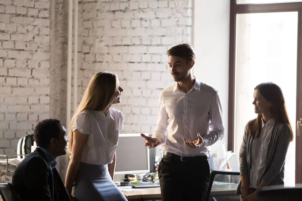 Vriendelijke zakenman grapje met diverse collega's tijdens pauze — Stockfoto