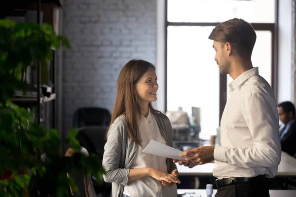 Amistoso mentor de hombre de negocios hablando con pasante sonriente, dando instrucciones —  Fotos de Stock