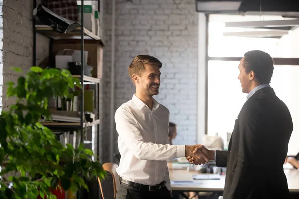 Smiling businessman shaking hand of African American colleague, greeting — Stock Photo, Image