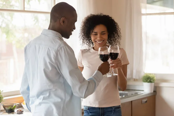 Loving biracial couple clink glasses celebrating having date — Stock Photo, Image