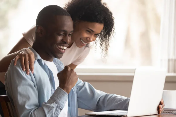 Excited biracial couple triumph win lottery on laptop online — Stock Photo, Image