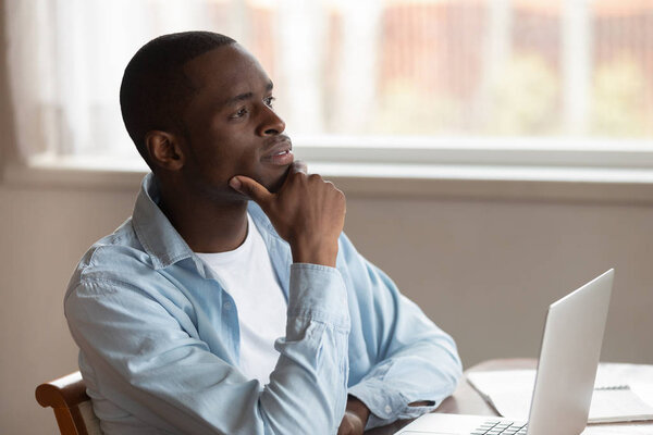 Pensive biracial man distracted from laptop work thinking