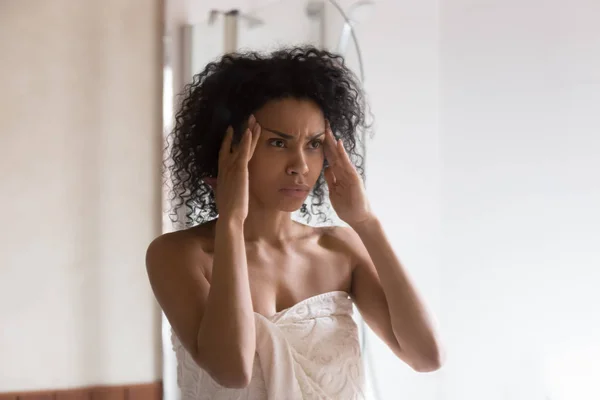 Mujer afroamericana ansiosa preocupada por las arrugas de la cara —  Fotos de Stock