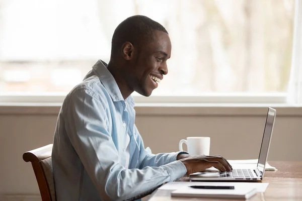 Excited biracial man type on laptop receive good news — Stock Photo, Image