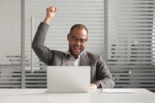 Vrolijke Afro-Amerikaanse manager die online wint of zakelijk succes viert. — Stockfoto