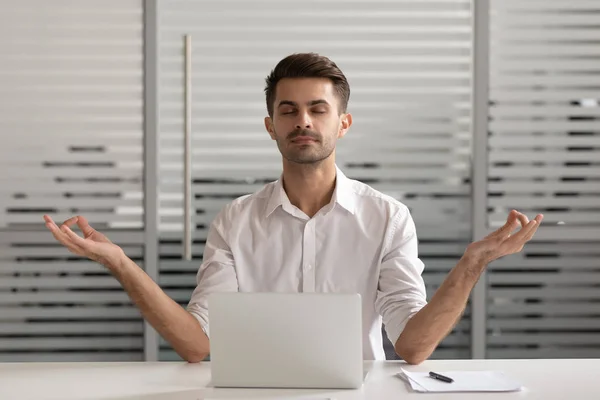 Mindful despreocupado millennial gerente masculino meditando no escritório . — Fotografia de Stock