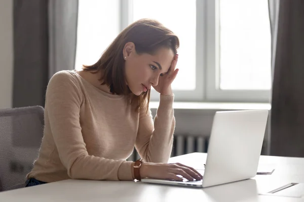 Vermoeide vrouwelijke medewerker die hoofd bij de hand houdt, lijdt aan hoofdpijn. — Stockfoto