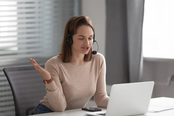 Busy female leader wearing headphones, holding conference video call with corporate client. — Stock Photo, Image