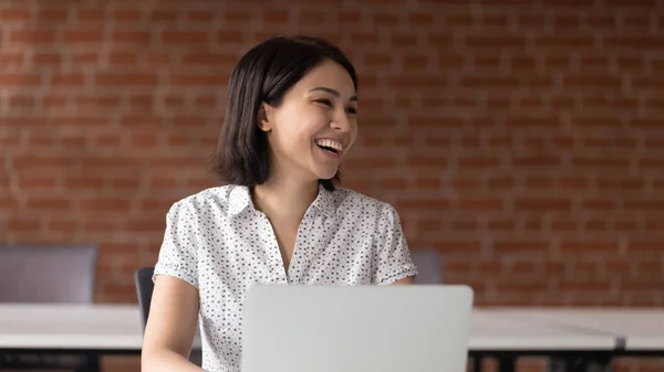 Cheerful asian business woman talking with somebody aside. — Stock Photo, Image