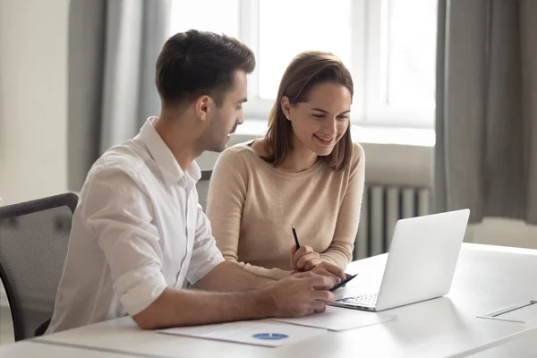 Employés heureux discutant de nouveaux logiciels de l'entreprise, regardant ordinateur portable . — Photo