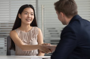 Gülümseyen mutlu asyalı genç profesyonel İk yöneticisi ile el sıkışma.