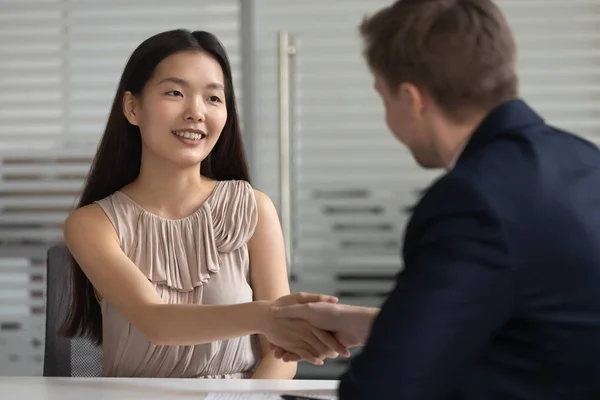 Glimlachend gelukkig Aziatisch jong professioneel schudden handen met HR Manager. — Stockfoto