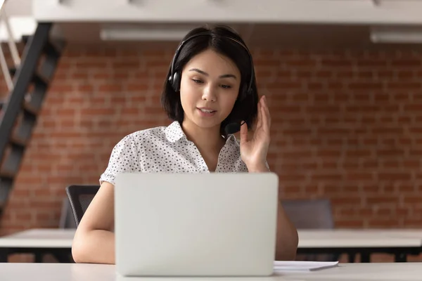 年轻的亚洲支持服务女工在耳机咨询客户. — 图库照片